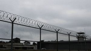 Immigration detention center exterior with fences and guard tower.